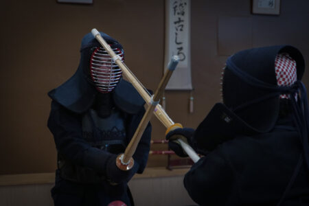 Kendo sparring match in Tokyo dojo with participants wearing full armor
