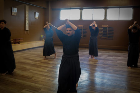 Practicing kendo strikes during a training session in Tokyo